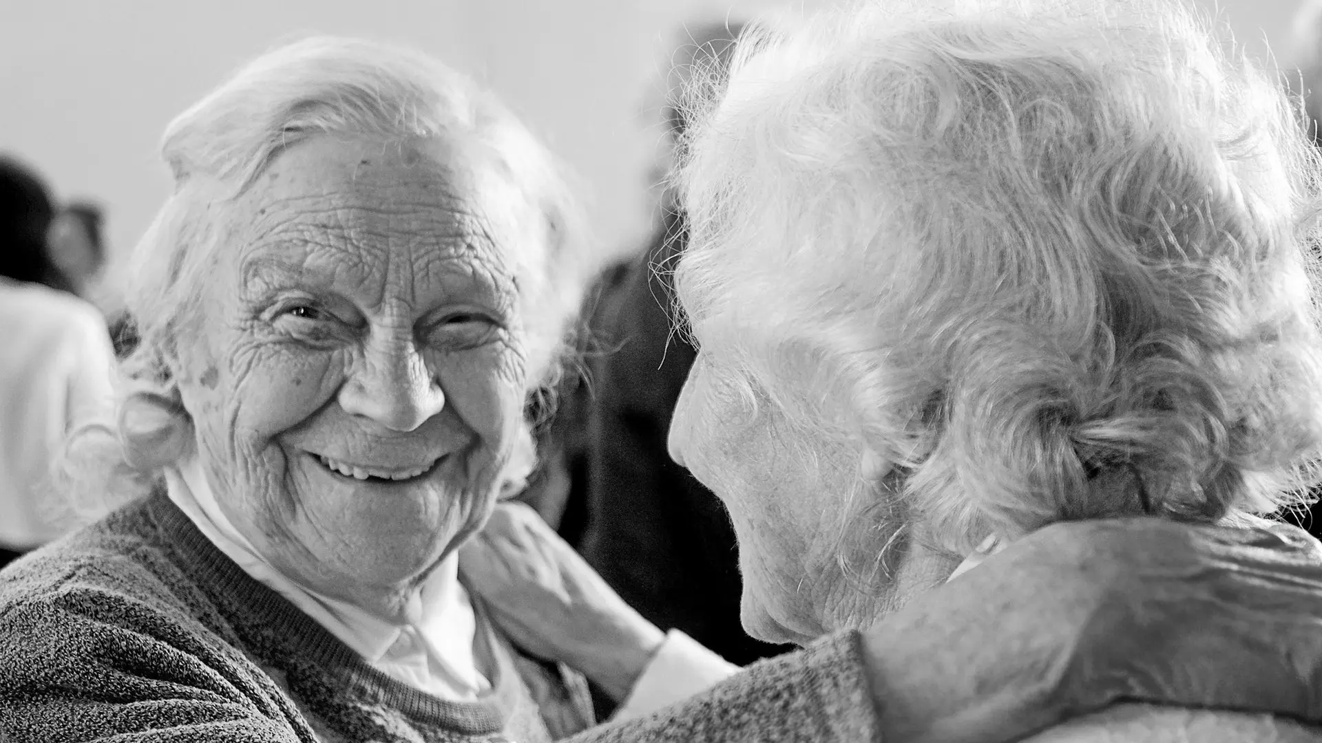Elderly ladies embracing with joy and a huge smile